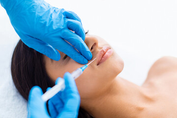 Pretty young indian half-naked woman getting lip filler at clinic