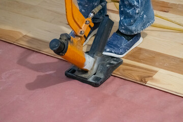 craftsman lays parquet floor and beats the floorboards with the hammer