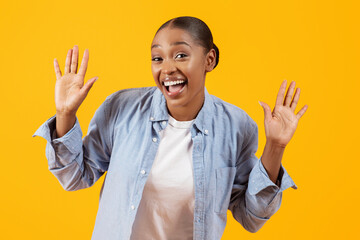 Excited black lady showing palms hands gesturing to camera, studio