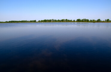 Landscape of a lake and blue sky reflected.