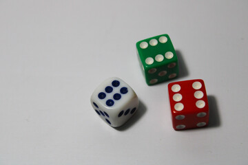 Close up of three different colored dice red, green, and white isolated on white background