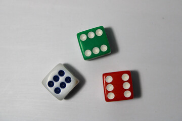 Close up of three different colored dice red, green, and white isolated on white background