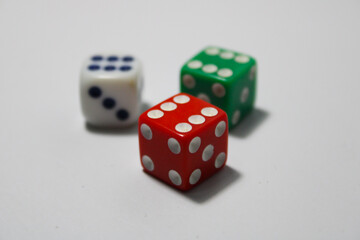 Close up of three different colored dice red, green, and white isolated on white background