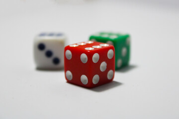 Close up of three different colored dice red, green, and white isolated on white background