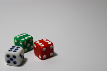 Close up of three different colored dice red, green, and white isolated on white background