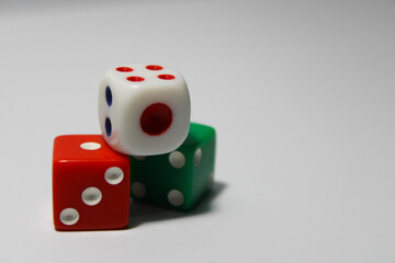Close up of three different colored dice red, green, and white isolated on white background