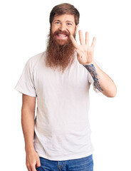 Handsome young red head man with long beard wearing casual white tshirt showing and pointing up with fingers number four while smiling confident and happy.