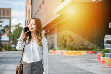 Young lawyer business woman walking street outdoor calling and talking on mobile phone with client, happy people smile talk on smartphone, cellphone communication