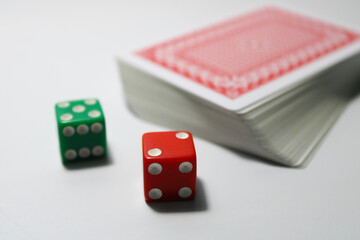 A deck of playing cards with two different colored dice green and red isolated on white background