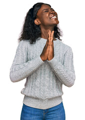 Beautiful african young woman wearing casual winter sweater begging and praying with hands together with hope expression on face very emotional and worried. begging.