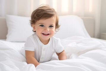 Obraz na płótnie Canvas baby lying on white bed and smiling, tightly cropped compositions