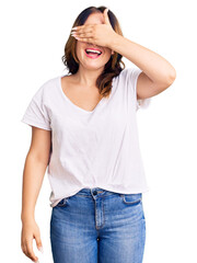 Fototapeta premium Young beautiful caucasian woman wearing casual white tshirt smiling and laughing with hand on face covering eyes for surprise. blind concept.