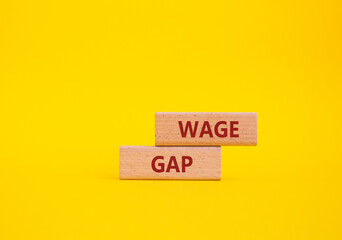 Wage Gap symbol. Concept words Wage Gap on wooden blocks. Beautiful yellow background. Business and...