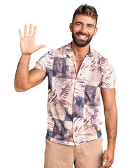 Young hispanic man wearing summer clothes showing and pointing up with fingers number five while smiling confident and happy.
