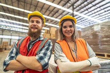 Team workers carpenter wearing safety uniform and hard hat working and checking the quality of wooden products at workshop manufacturing. man and woman workers wood in dark warehouse industry.