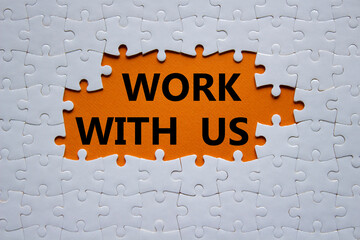 Work with us symbol. Concept words Work with us on white puzzle. Beautiful orange background. Business and Work with us concept. Copy space.