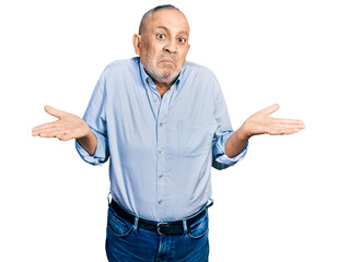 Senior man with grey hair and beard wearing casual blue shirt clueless and confused expression with...