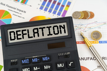 On the table are financial reports, coins and a calculator with the inscription - DEFLATION
