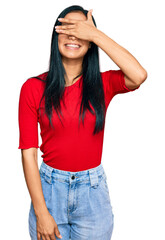 Fototapeta premium Beautiful hispanic woman wearing casual clothes smiling and laughing with hand on face covering eyes for surprise. blind concept.