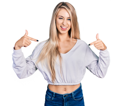 Beautiful young blonde woman wearing casual white sweater looking confident with smile on face, pointing oneself with fingers proud and happy.
