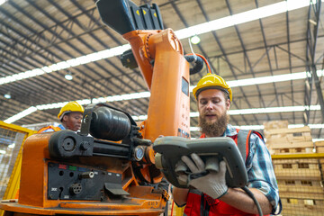 Factory engineer inspecting on machine. Workers work at heavy machine robot arm. The welding...