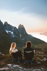 Couple man and woman travel together enjoying mountain view in Norway outdoor healthy lifestyle...