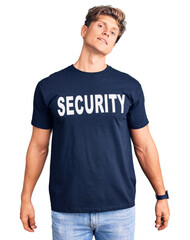 Young handsome man wearing security t shirt looking sleepy and tired, exhausted for fatigue and hangover, lazy eyes in the morning.