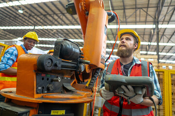 Factory engineer inspecting on machine. Workers work at heavy machine robot arm. The welding...