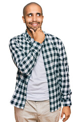 Fototapeta premium Hispanic adult man wearing casual clothes with hand on chin thinking about question, pensive expression. smiling with thoughtful face. doubt concept.