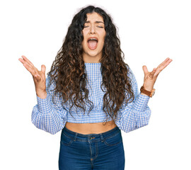 Young hispanic girl wearing casual clothes celebrating mad and crazy for success with arms raised...