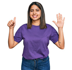 Young hispanic girl wearing casual purple t shirt showing and pointing up with fingers number six while smiling confident and happy.