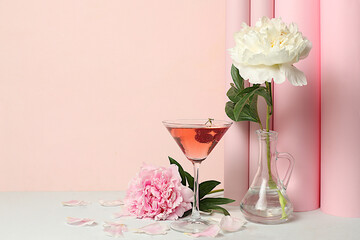 Modern still life with pink martini, alcoholic cocktail and peony flowers on elegant modern...