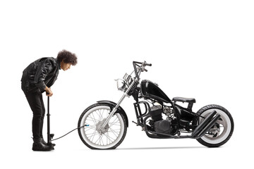 Obraz premium Full length profile shot of a young man pumping a flat motorbike tire