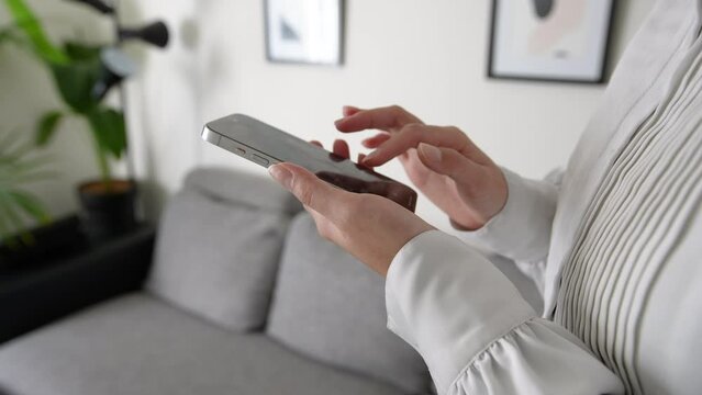 自宅でスマートフォンを操作する日本人女性