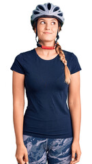 Beautiful caucasian woman wearing bike helmet smiling looking to the side and staring away thinking.