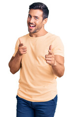 Fototapeta premium Young hispanic man wearing casual clothes pointing fingers to camera with happy and funny face. good energy and vibes.