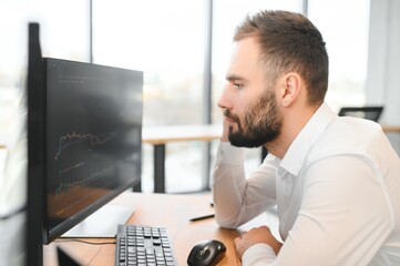 business man looking at the charts of the stock market of cryptocurrencies on the PC screen