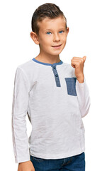 Adorable caucasian kid wearing casual clothes smiling with happy face looking and pointing to the side with thumb up.