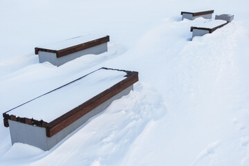Four benches buried in snowdrifts, swept away after a strong snowstorm