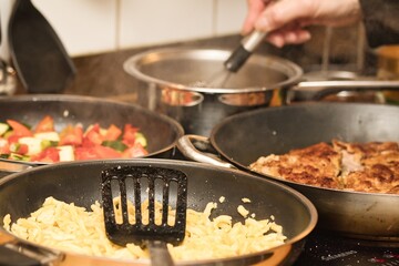 Schnitzel mit Spätzle und Gemüse auf dem Herd zubereiten - 710057825