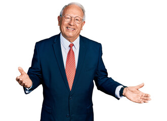 Senior man with grey hair wearing business suit and glasses smiling cheerful with open arms as...