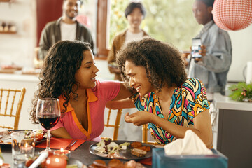 Smiling female friend supporting upset young woman during home party. Friendship concept