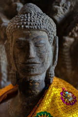 Buddha sculpture with golden kata on the shoulders at Bayon Temple, Siem Reap, Cambodia