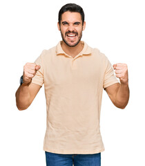 Young hispanic man wearing casual clothes screaming proud, celebrating victory and success very excited with raised arms
