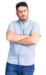 Young hispanic man wearing casual clothes skeptic and nervous, disapproving expression on face with crossed arms. negative person.