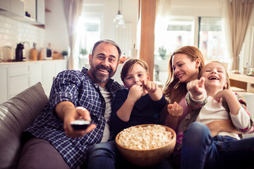 Happy family enjoying a movie with popcorn at home
