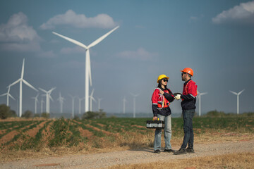 two professional engineer,worker,technician. renewable energy, power and wind turbine. Electrician or technician man and woman, eco and green environment engineer working in wind turbine farm.