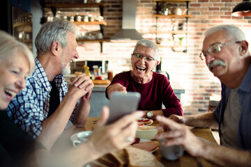 Group of senior friends enjoying conversation and breakfast together