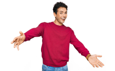 Young handsome man wearing casual clothes looking at the camera smiling with open arms for hug. cheerful expression embracing happiness.