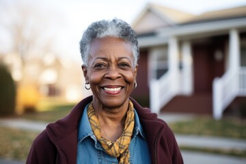 Portrait of a smiling black senior woman in front of her house